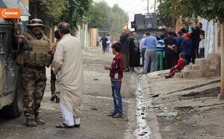 Photo shows residents in Mosul's Zahra chat, laugh after Iraqi army retook the northeastern neighborhood from ISIS in early November. Photo Rudaw