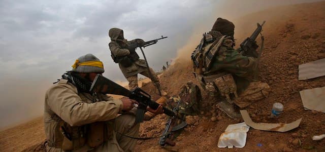 Hashd al-Shaabi fighters fire their weapons as they advance near near a town, west of Mosul. AFP file photo