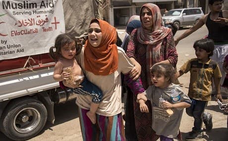 Iraqi women, who fled the fighting between government forces and ISIS extremists in the Old City of western Mosul, arrive in the industrial district to be relocated on July 8. Photo: Fadel Senna | AFP