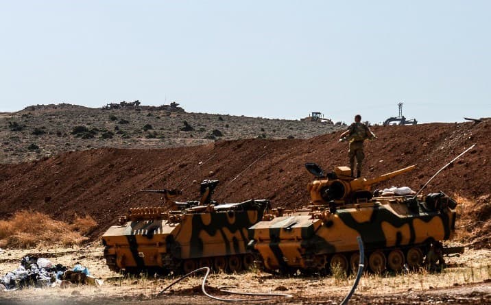 A Turkish soldier stands on an armoured vehicle on Turkey’s border with Syria’s Idlib on Sunday. Photo: Ilyas Akengin/AFP