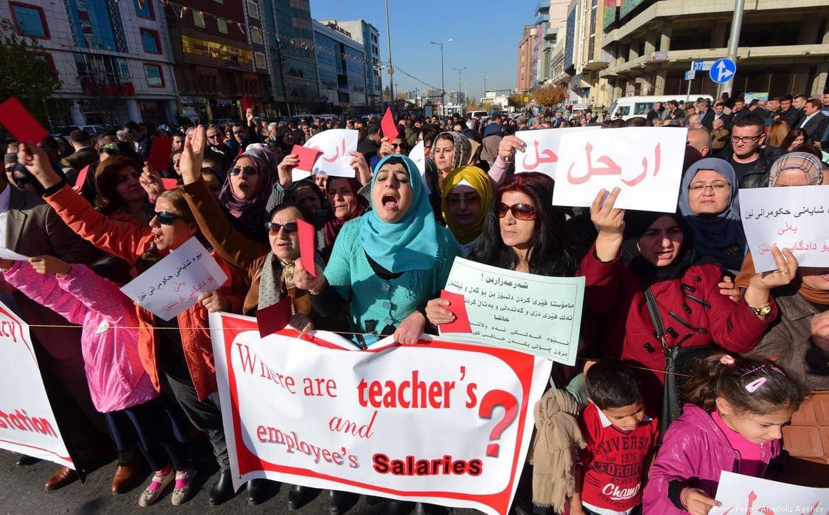 Protesters hold signs asking about civil servant salaries during a demonstration in Sulaimani on December 18. Photo: Feriq Ferec/Anadolu Agency