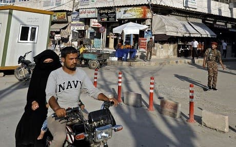 A picture taken on June 6, 2018, shows a family riding a motorcycle in a street in Manbij. Photo: Delil Souleiman AFP