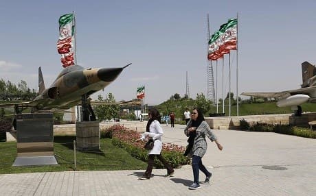 Iranians walk past a fighter jet at the Holy Defence Museum in Tehran. Photo: Atta Kenare/AFP