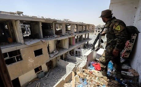 A member of the People's Protection Units (YPG) moves through destroyed buildings in Raqqa on July 28, 2017. File photo: Delil Souleiman | AFP