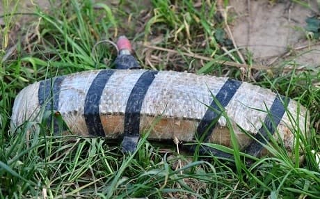This picture taken on March 15, 2019 shows a discarded explosive belt in the grass at the remains of an Islamic State (IS) group jihadists' camp near the village of Baghouz in the eastern Syrian province of Deir Ezzor. Photo: Giuseppe Cacace | AFP