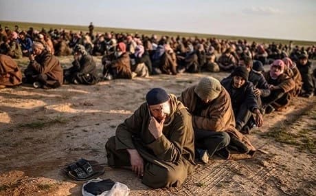 Suspected ISIS fighters wait to be searched by the SDF after leaving the group's last holdout of Baghouz, Syria, February 22, 2019. Photo: Bulent Kilic / AFP