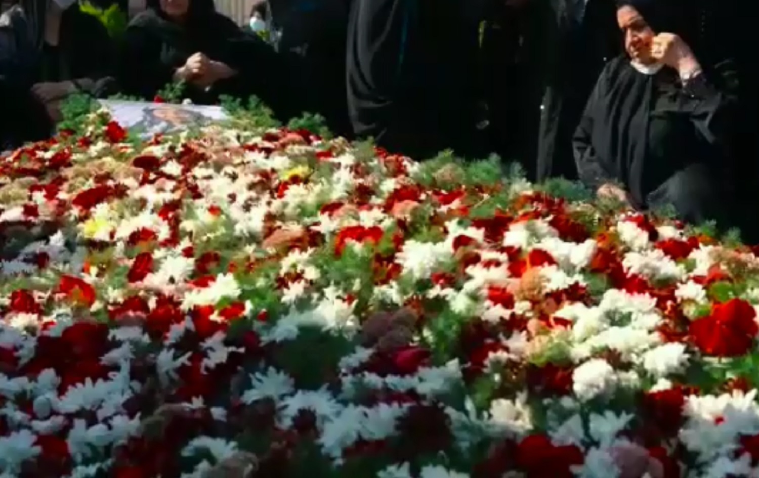 A bed of flowers adorns the grave of Naji Sharifi Zindashti's mother on September 11, 2020. Photo: screenshot taken from video posted to a local Telegram channel