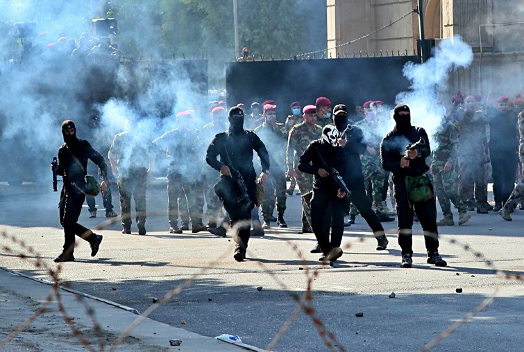 Iraqi security forces fire tear gas to disperse anti-government protesters, October 25, 2019. Photo: Hadi Mizban / AP