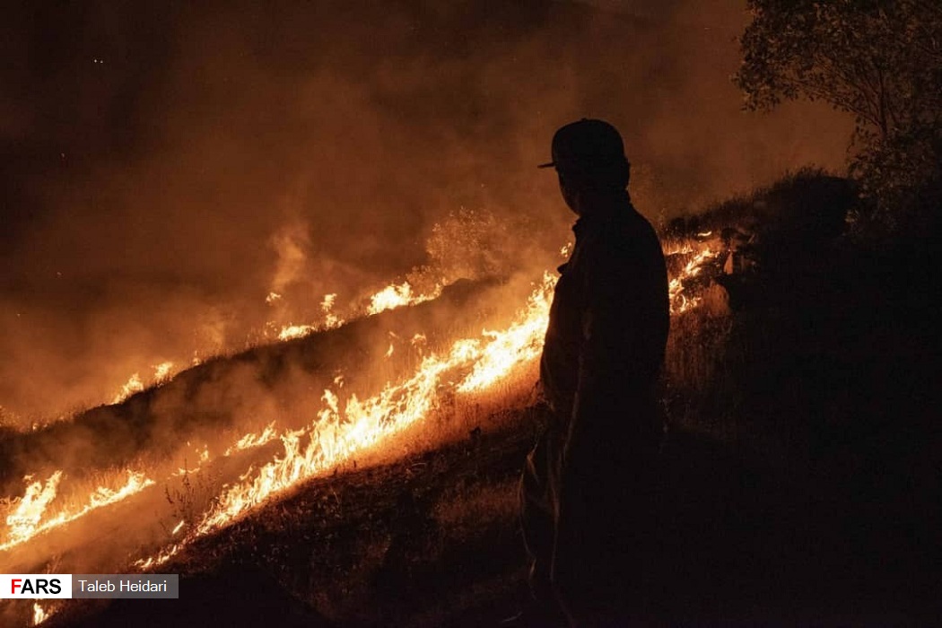 هاووڵاتییەک بەدیار سووتانی دارستانەکانی پاوە