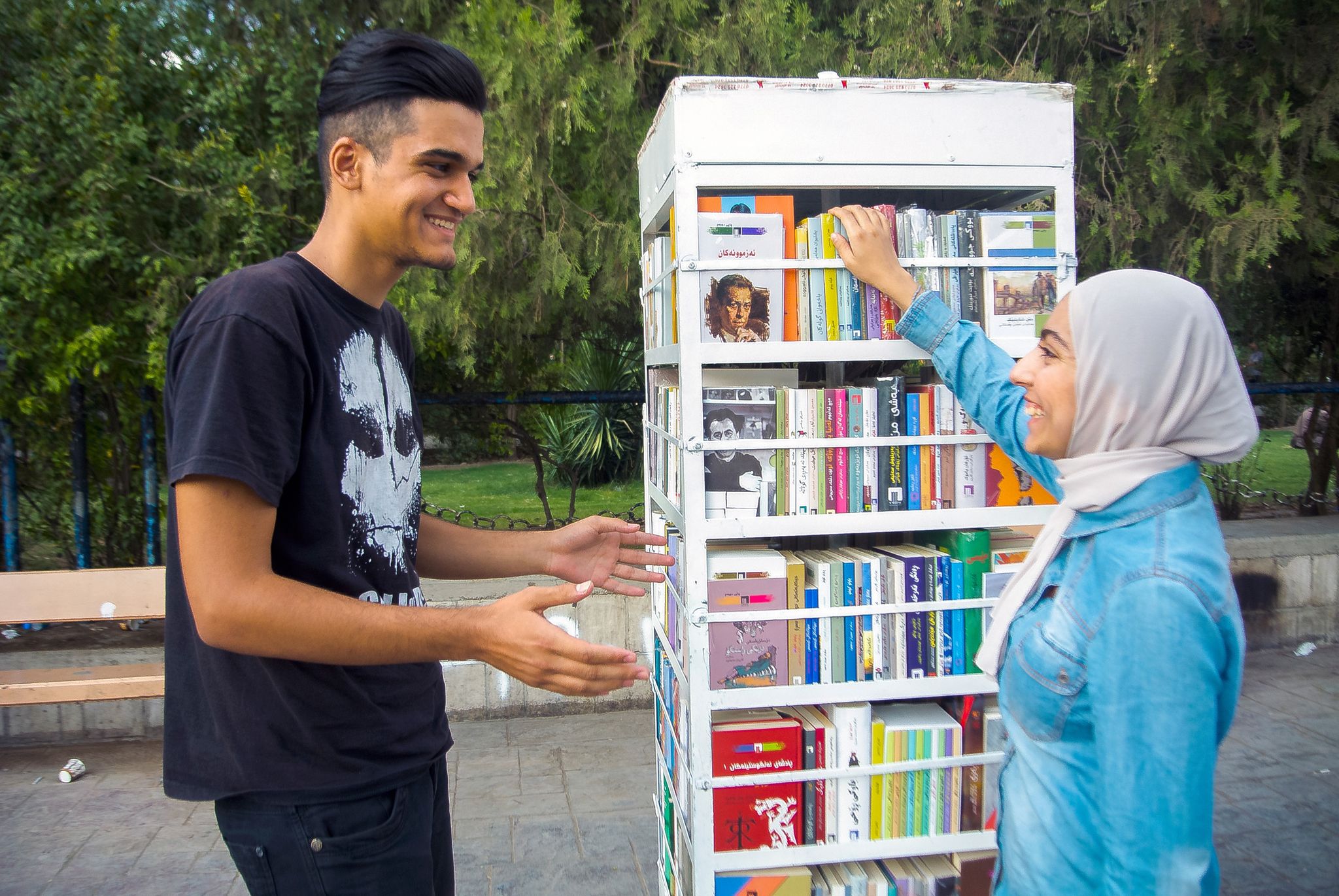 چراخان تۆفیق و زامۆ عومەر لە تەنیشت کتێبفرۆشییە بچووکەکەیان. وێنە؛ زمناکۆ ئیسماعیل