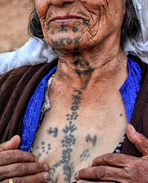 Alt dudakta çiçek halka sembolleriyle çeşitli astral ve bitki motifleri. Göğüs üzerine buğday sembolü