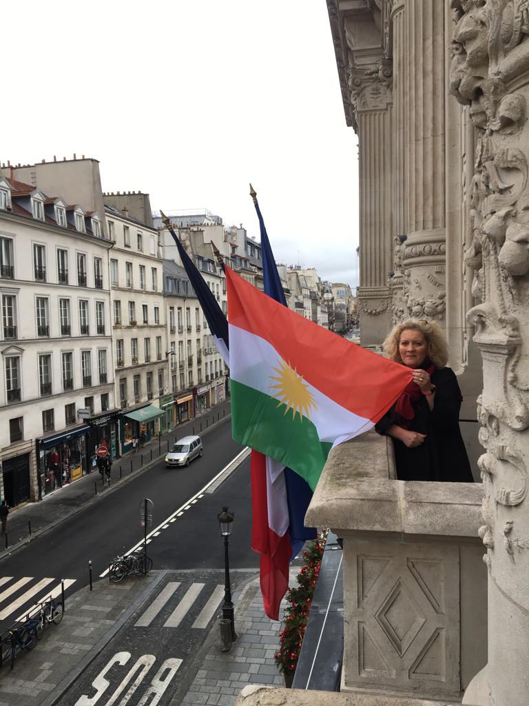 ئەلێکساندرا کۆردێبارد، سەرۆکی شارەوانیی بازنەی 10ی پاریس لە کاتێکدا کە ئاڵای کوردستانی بەرزکردووەتەوە