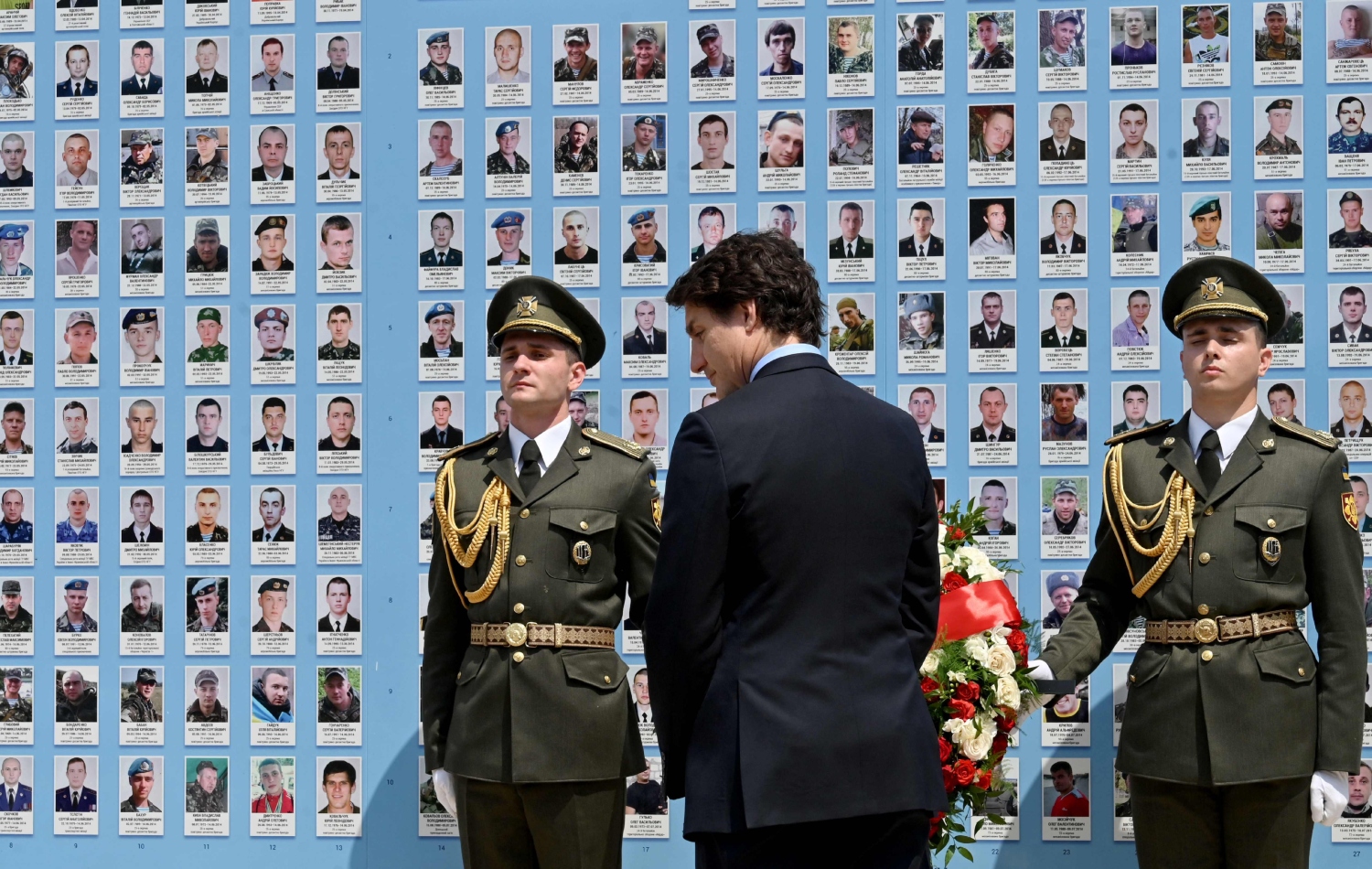 جەستن ترودۆ، سەرۆکوەزیرانی کەنەدا تاجەگوڵینە لەسەر ئەو دیوارە دادەنێت، کە بۆ رێزگرتن لە سەربازە کوژراوەکانی ئۆکراینا لە کیێڤ دروستکراوە، وێنە: Sergei SUPINSKY / AFP