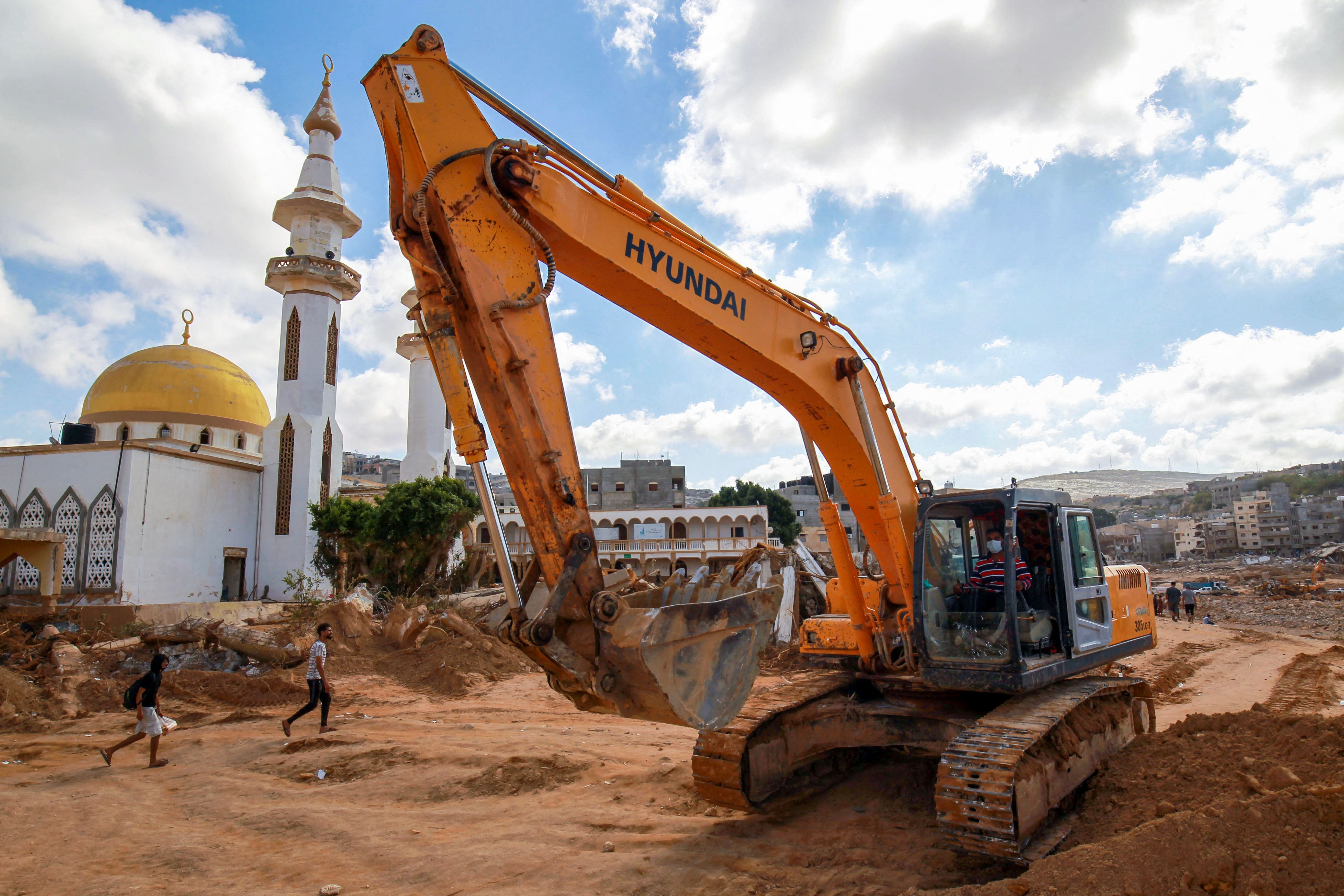 حەفارەیەک کار بۆ پاککردنەوەی قوڕ و لیتەی لافاوەکە دەکات. وێنە: AFP
