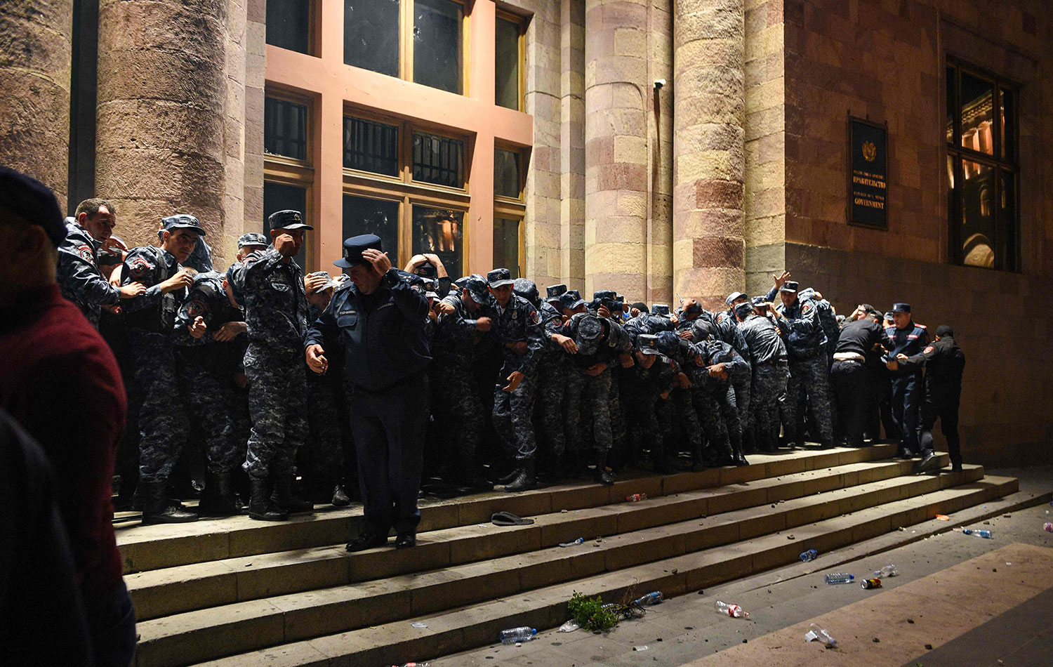 Erivan'da Ermenistan Başbakanı Nikol Paşinyan'ı istifaya çağıran protestocularla çıkan çatışmalar sırasında polis hükümet binasının girişini kapattı. / AFP