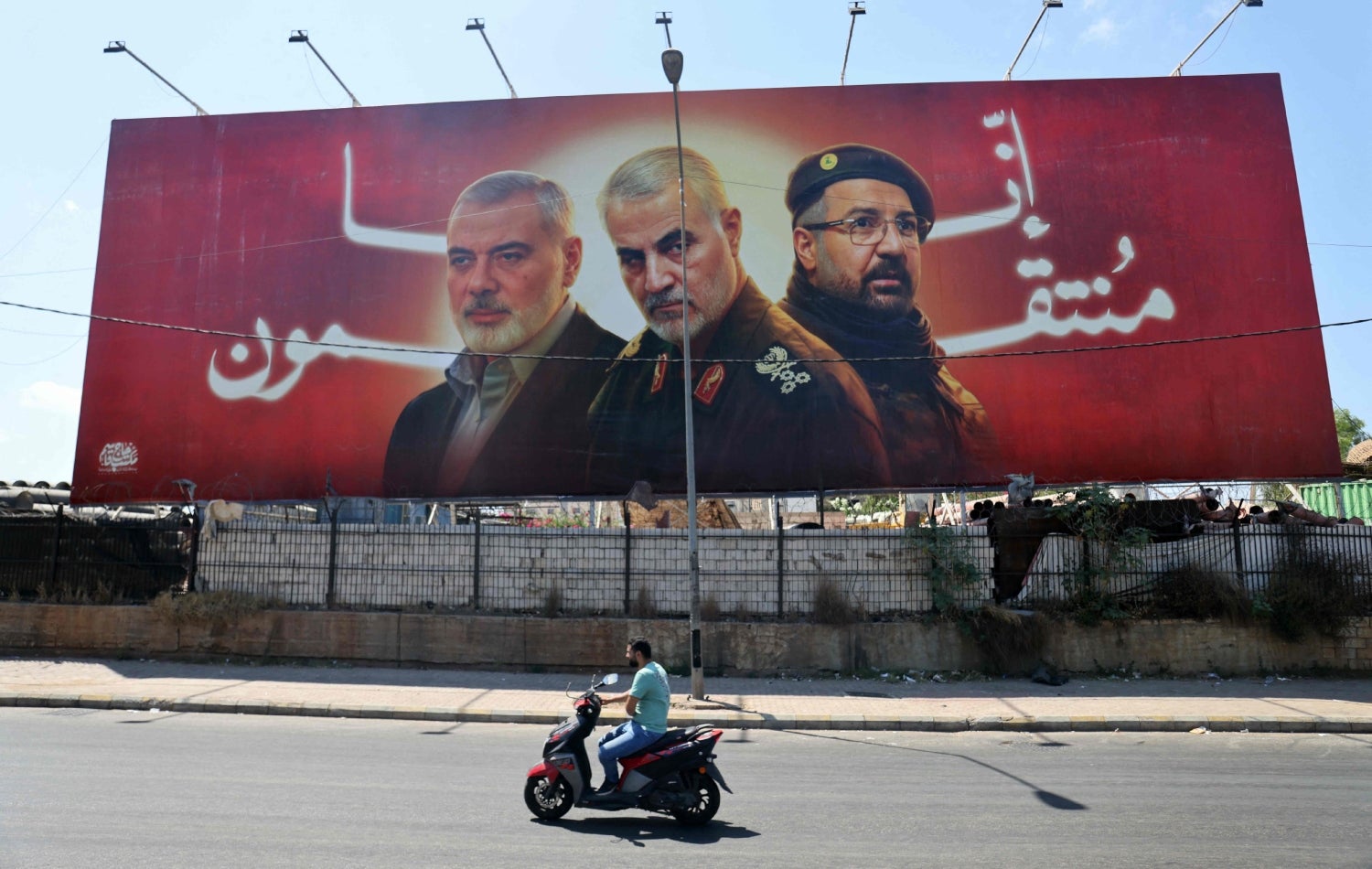 وێنەی سەرکردە کوژراوەکانی ئیسماعیل هەنیەی حەماس، قاسم سولەیمانیی سوپای پاسداران و فوئاد شوکری حیزبوڵڵا کە لە پشتیانەوە نووسراوە "تۆڵەتان دەکەینەوە" لە سەر شەقامێکی بەیرووت دانراوە، وێنە: Ibrahim AMRO / AFP