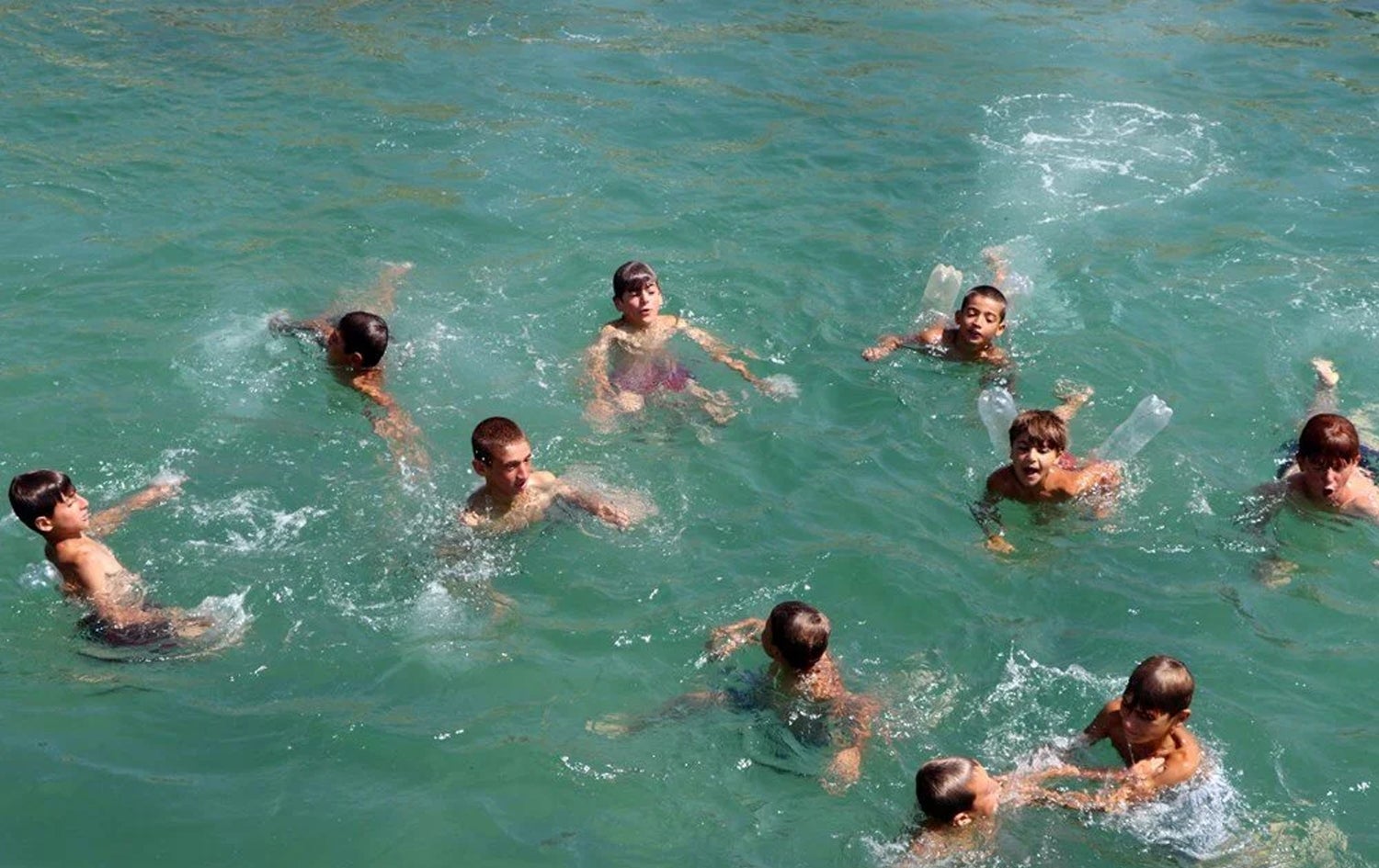 ژمارەیەک منداڵ لە دەریاچەی وان مەلە دەکەن