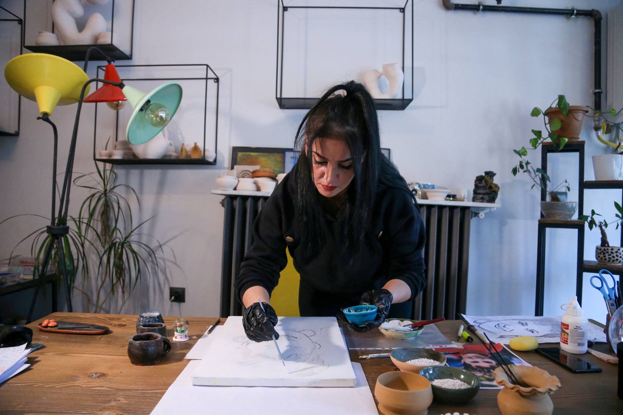 سەراب لۆکماجی لە کاتی کێشانی تابلۆ بە خۆڵەمێشی جەستە