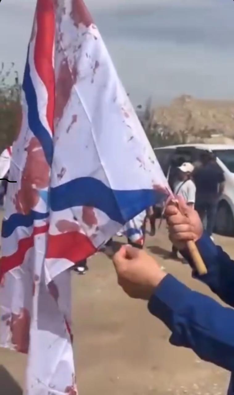 Screengrab from a video showing a bloodied Assyrian flag that was carried by the 20-year-old man as he was attacked with an axe. Photo: Submitted