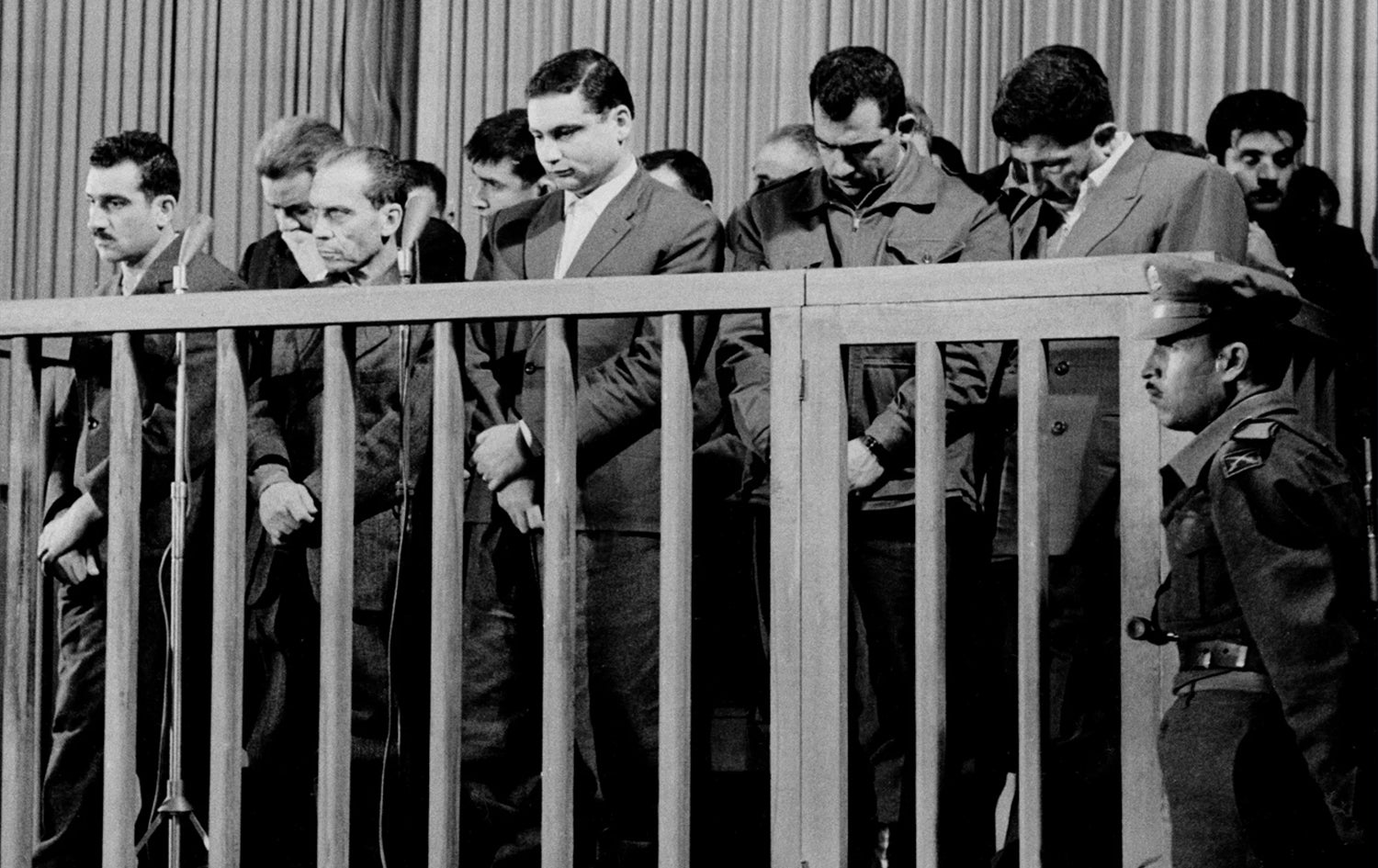 ئیلی کۆهین، لەو پەڕی لای چەپەوە، سەرۆکی ئەڵقەیەکی سیخوڕی ئیسرائیل، گوێ دەگرێت کاتێک لەلایەن دادگایەکی سەربازی تایبەتەوە لە دیمەشق لە سووریا، لە 8ی ئایاری 1965 سزای لەسێدارەدانی بەسەردا سەپێندرا.