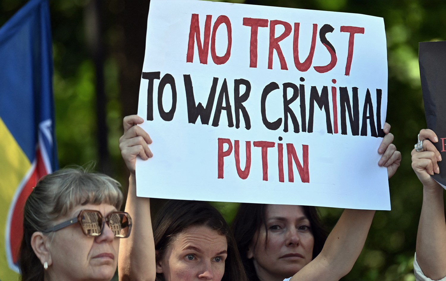 پاڵپشتیکارێکی ئۆکراینا درووشمی "هیچ متمانەیەک بە تاوانکاری جەنگ، پووتین ناکرێت." وێنە: AFP