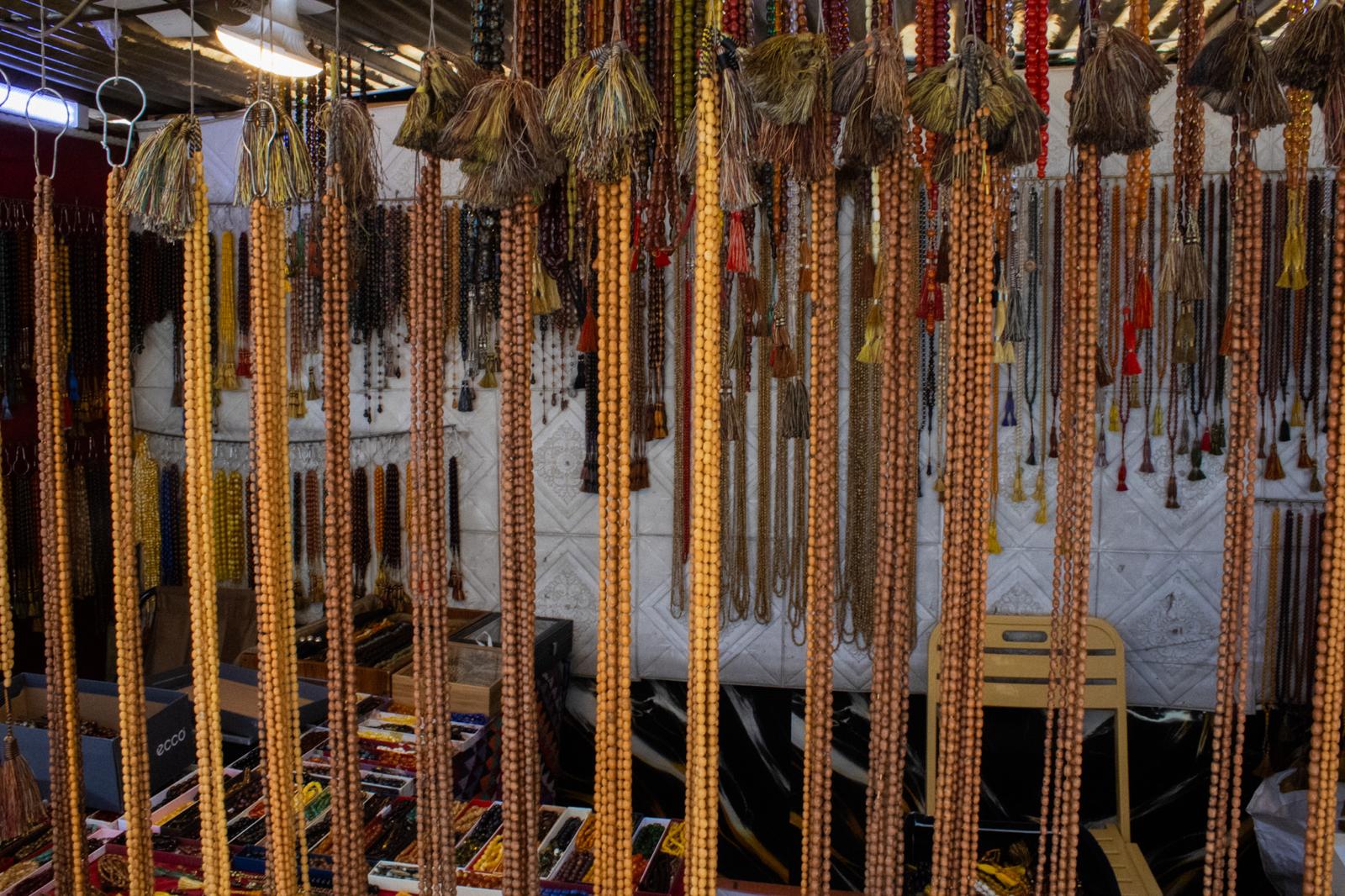 Qazwan prayer beads hang above a stand for display in Erbil's bazaar around the citadel on July 22, 2025. Photo: Sehend Mayiwar/Rudaw