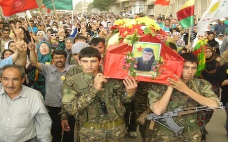 Members of the People's Defense Units (YPG) and residents of Amude carry the body of Demhat Nergiz, a YPG fighter killed in clashes with Islamic rebels last month, for burial. Photo: PYD