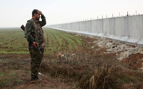 A kurdish fighter stands infront of the former Syrian military Menagh airbase, AFP Photo.