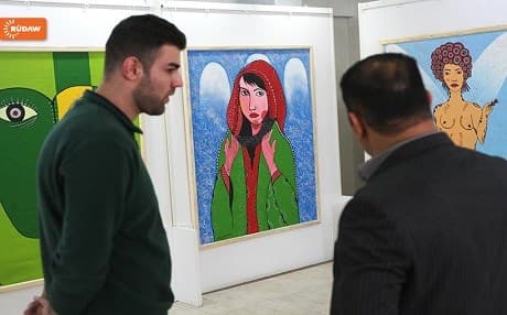 Two men admiring an exhibition by Kurdish female artists on the international women's day in Sulaimani, Kurdistan Region. March 8, 2016. 