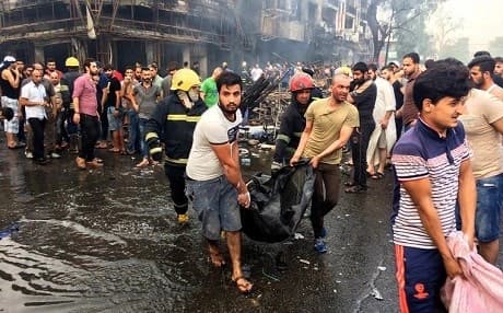 Volunteers carry victims from the scene of a suicide bombing in Karrada, Baghdad on Sunday. Photo: Khalid Mohammed/AP