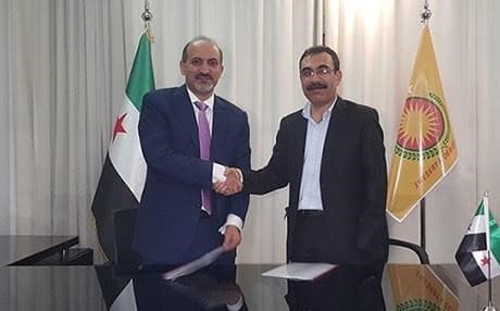 Rojava envoy Aldar Khalil shaking hands with Ahmed Jarba, head of the Al-Ghad Front, in Cairo. 