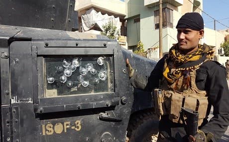 A soldier from the Iraqi army's Golden Division showing the number of ISIS sniper hits on the window of his armored vehicle in one of the interior neighborhoods of Mosul. Photo by Ayub Nuri