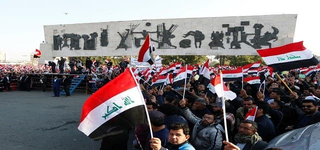 Iraqi supporters of the Sadrist movement hold national flags during a demonstration in Baghdad's Tahrir Square. Photo:AFP / Sabah Arar