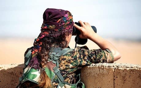 A member of the YPJ, the women’s arm of the Kurdish YPG, survey’s a battlefield 40km from Raqqa last November. Photo: Delil Souleiman/AFP