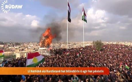 Kurdish and Iraqi flags flying side-by-side over a Newroz fire in Kirkuk on Monday. Photo: Rudaw video