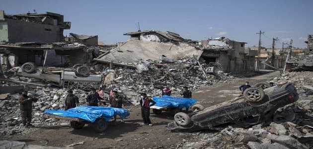 Residents carry the body of several people killed in an alledged US-led coalition airstrike carried out on March 17 that hit a cluster of homes in western Mosul. Photo: AP Photo/Felipe Dana