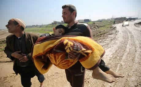 A displaced Iraqi man from Mosul carries the body of his son, who was killed in the government forces ongoing offensive to retake the city from from ISIS group fighters. Photo: AFP / Ahmad Al-Rubaye