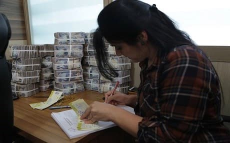 A bank worker in Kurdistan Region. Kurdish Region does not have  a strong banking system which may make the tax collection difficlut to be applied. Photo: Rudaw 