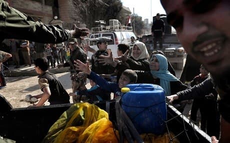 Iraqi forces distribute food aid to west Mosul resident. Photo: Aris Messinis/AFP
