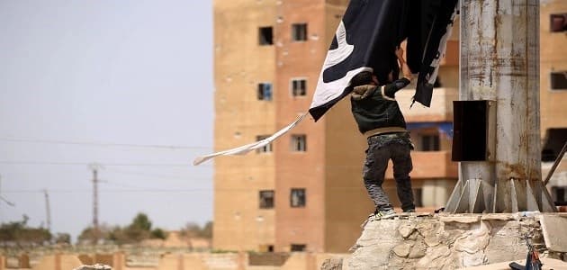  A member of the US-backed Syrian Democratic Forces (SDF) removes an ISIS  group flag in the town of Tabqa, about 55 kilometres west of the ISIS-held of Raqa city. Photo: AFP/Delil Souleiman