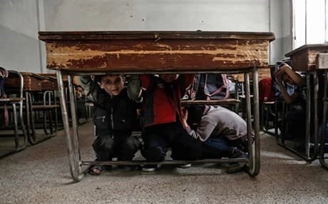 Syrian school children learn how to protect themselves in case of a bombardment during a war safety awareness class in the rebel-held area of Harasta on May 3, 2017. Photo: AFP
