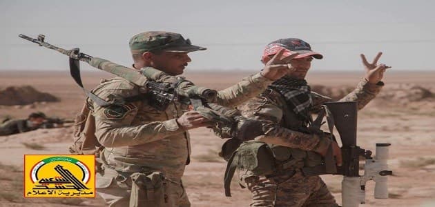 Members of the mainly Shiite Hashd al-Shaabi gesture as they take part in their offensive against the ISIS militants west of Mosul. Photo: Hashd al-Shaabi media office. 