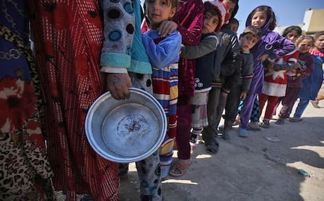 AFP file photo of west Mosul residents queuing for a meal.