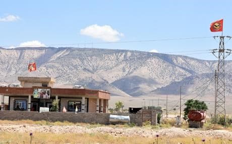 A home in the Shingal region displays YBS and Ezidi flags and PKK leader Abdullah Ocalan's portrait. Photo: Rudaw