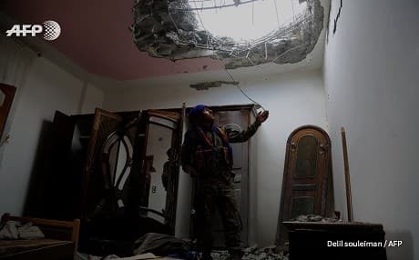 A Syrian Democratic Forces fighter eyes a hole in the ceiling of a structure in the Mushalab neighborhood of eastern Raqqa. Photo: Delil Souleiman | AFP