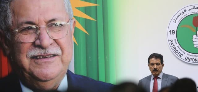 First deputy head of the Patriotic Union of Kurdistan (PUK) Kosrat Rasul is seen next to a portrait of the party's head and founder Jalal Talabani. File photo: Rudaw