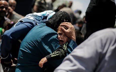 A child cries while crossing the Tigris River in Mosul last month. Photo: AP