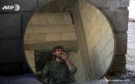 A fighter with the Kurdish YPG speaks on a walkie-talkie in Raqqa last week. Photo: Delil Souleiman/AFP