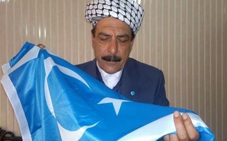 Niyazi Mimamr Oglu, a Turkmen MP, carried the Turkmen flag. He introduced the bill to recognize the ISIS persecution of Turkmens as genocide. Photo: Ogly Facebook page. 