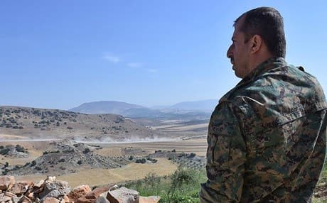 A fighter from the YPG monitors the area of Afrin on June 9. Photo: George Ourfalian | AFP
